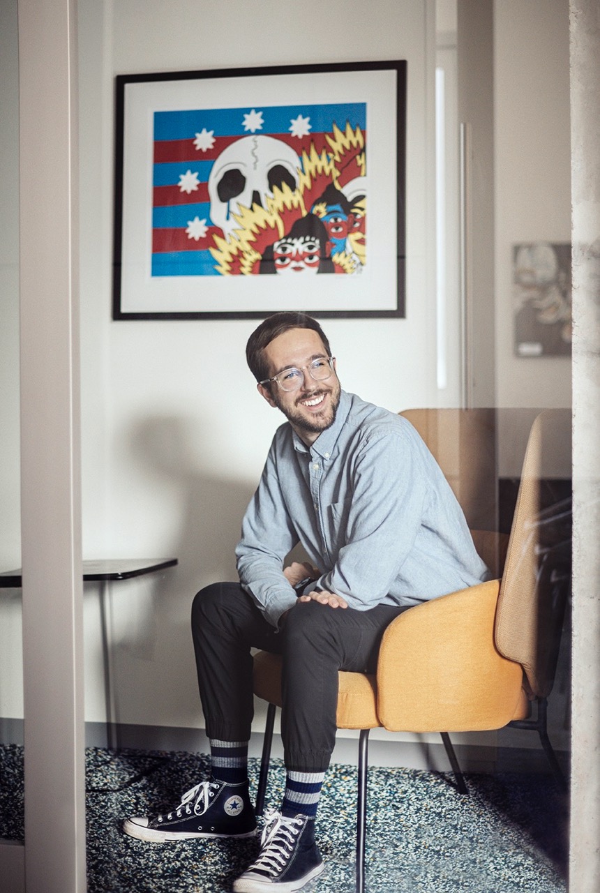Portrait de Jérémy Beaulne qui porte une chemise bleue, assit sur une chaise jaune.